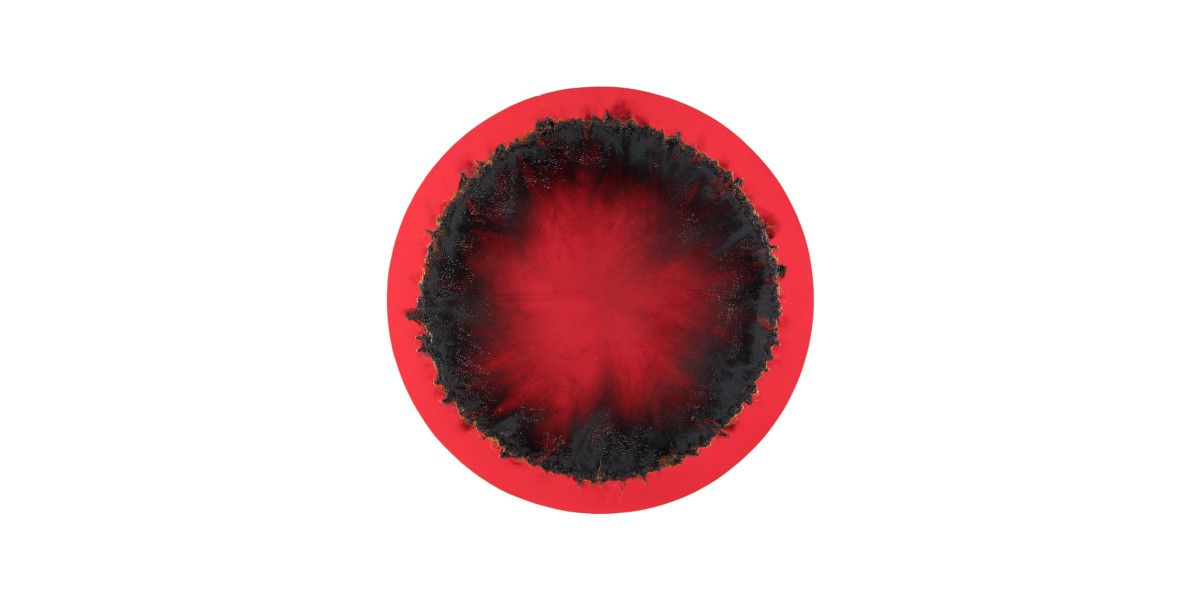 Une œuvre de Christian Jaccard représentant un rond rouge avec une zone brûlée en périphérie extérieure.